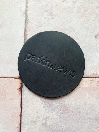 parkin and lewis stamped on a black leather coaster.