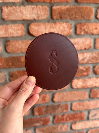 Chocolate brown leather coaster with the schwepps logo debossed on it.